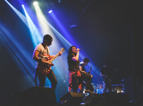 Band performing live on stage under blue stage lighting